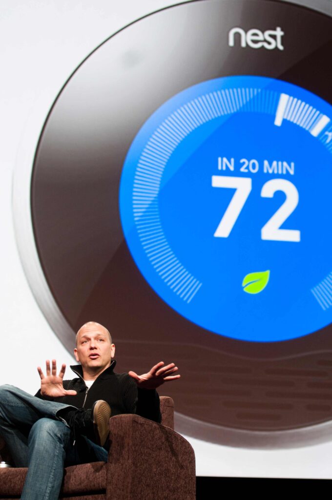 The inventor/Owner of the Nest thermostat speaks about is product onstage with the product displayed in the background