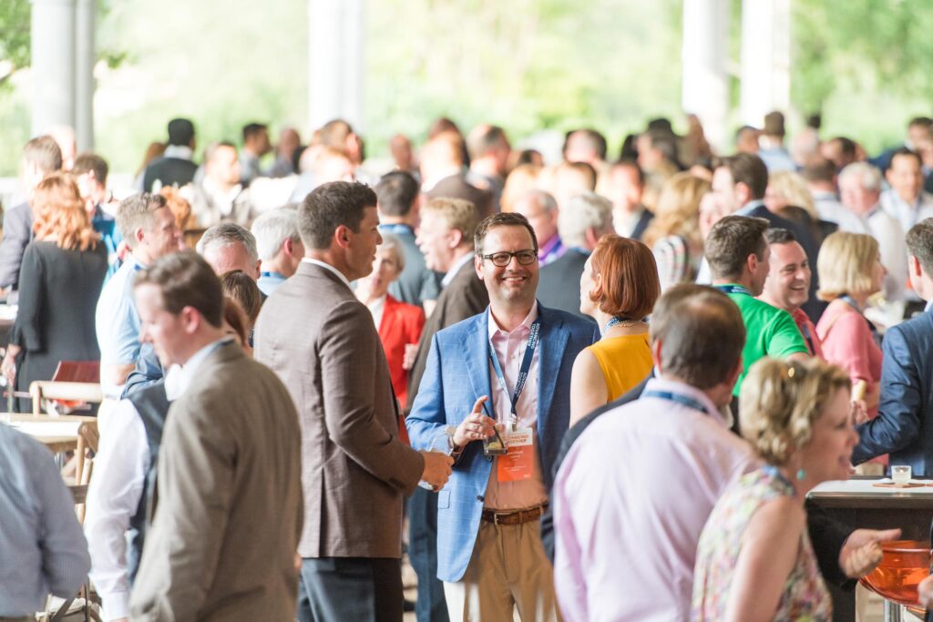An Event photo of Employees mingle at a company event in a crowd