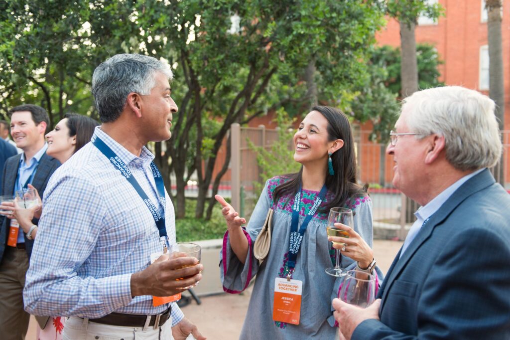 Employees talk outside at a company retreat wearing lanyards
