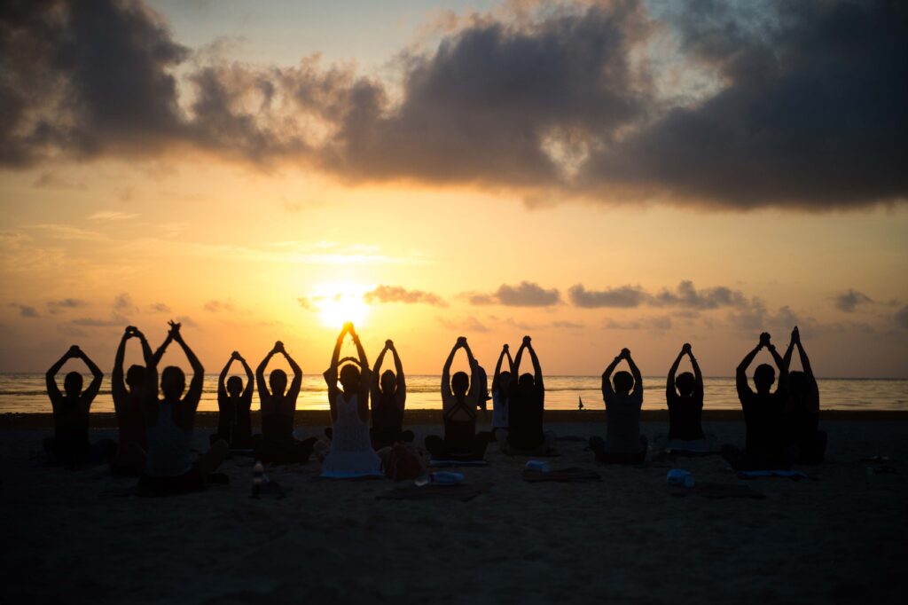 Yoga class on the beach at a company retreat in San Diego during sunset