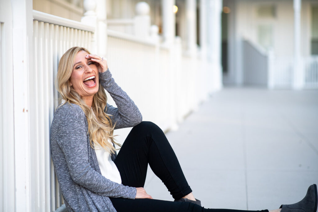 Woman wearing a gray cardigan while sitting on the pavement