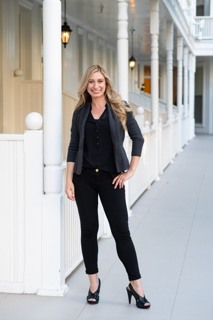 Woman wearing a black casual business outfit, posing with her hand on her hip for her personal branding photo