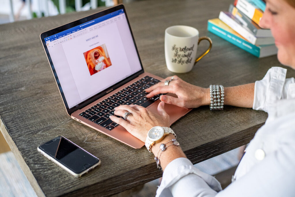 Close up of a woman using her pink laptop