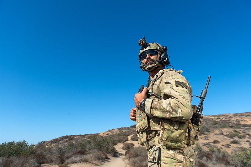 Military personnel standing outdoors, while wearing full active gear