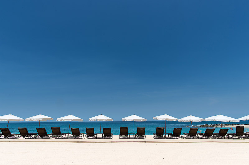 A row of beach chairs and umbrellas lined up on a picturesque beach