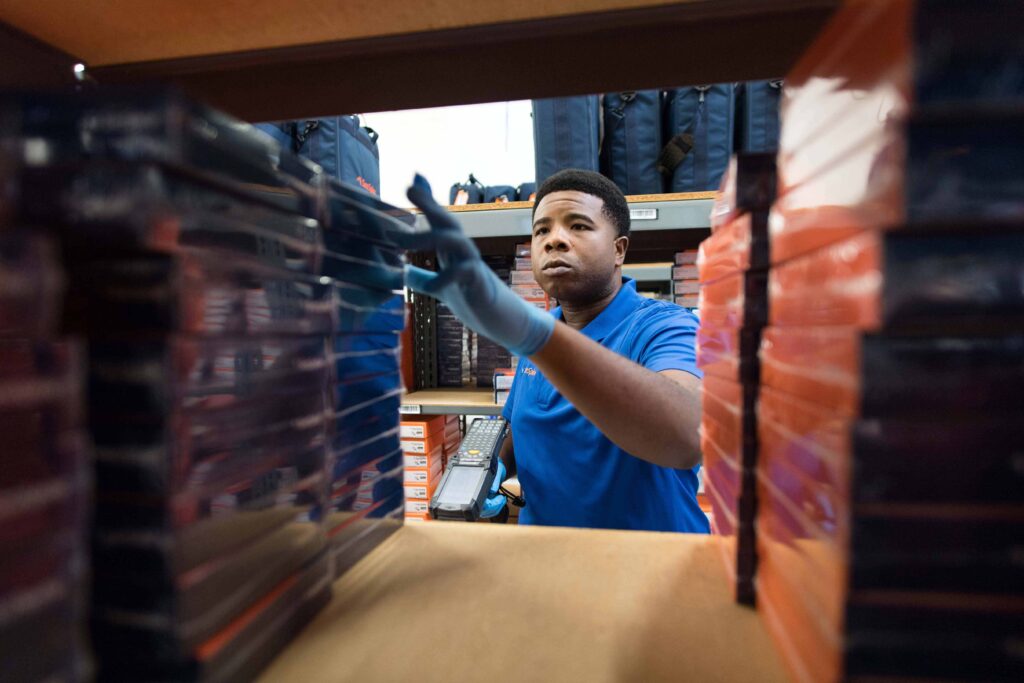 Man with gloved hands checking the stocks in a storage room