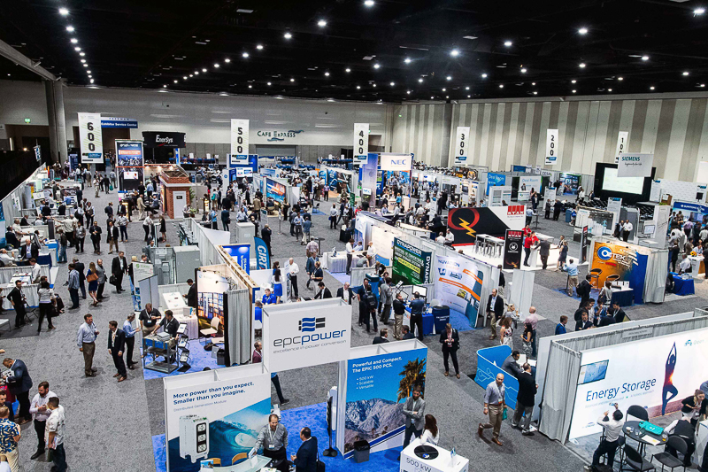 A bustling convention hall filled with attendees exploring various booths and displays