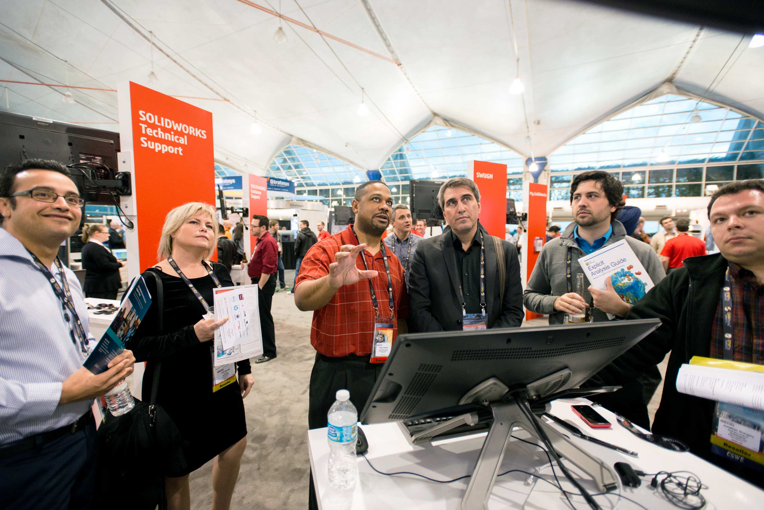 A group of professionals engaged in a discussion at a trade show booth