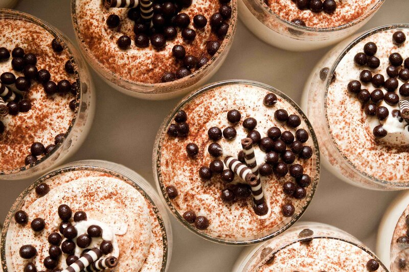 Overhead view of dessert cups topped with chocolate and cocoa powder