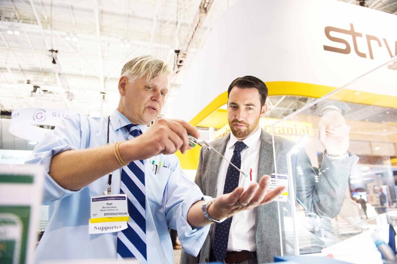 Two men examining a display of various electronic devices in a retail setting